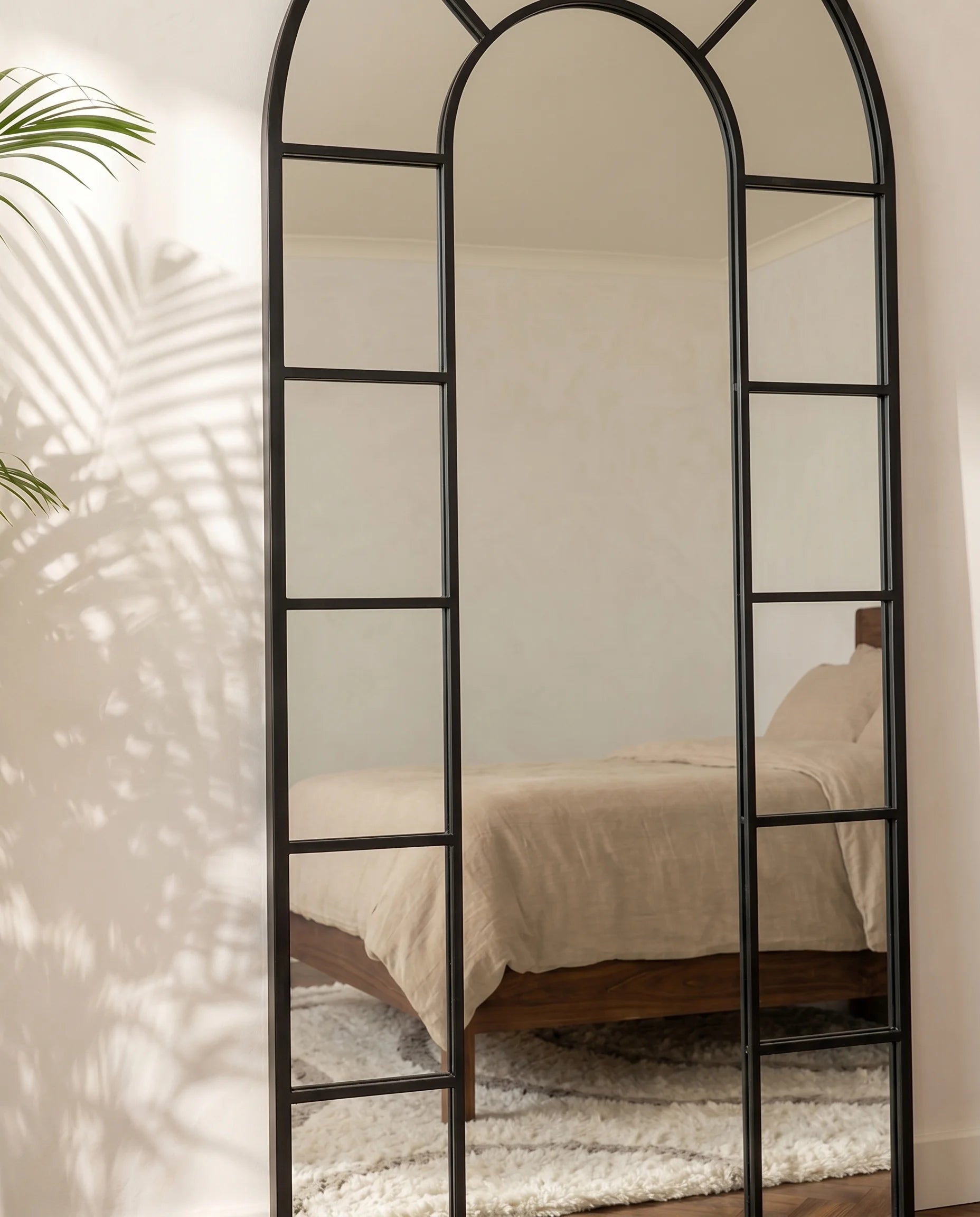 Charles black window-pane arched mirror in a Dubai living room