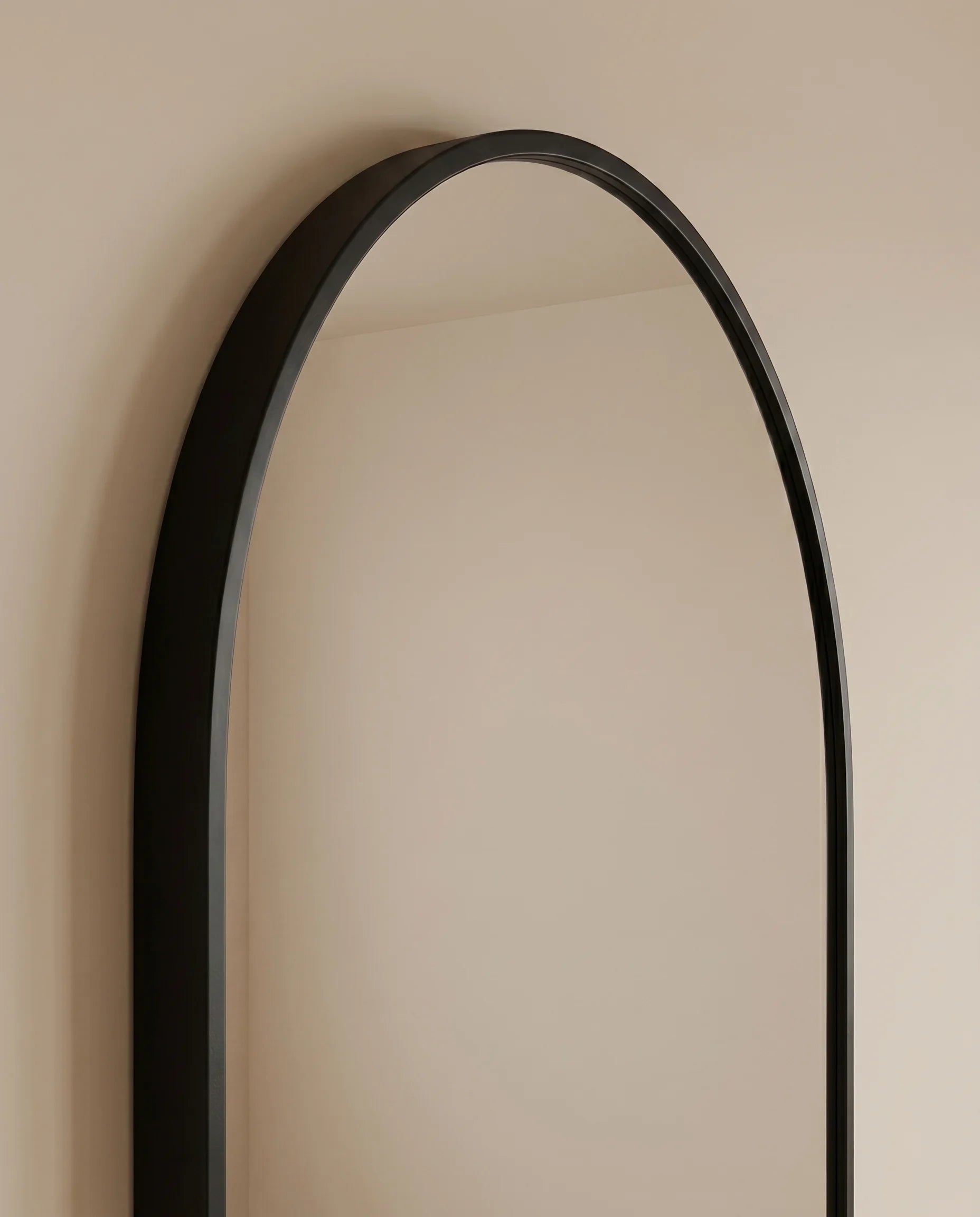 Gothic black framed capsule wall mirror in a Dubai hallway