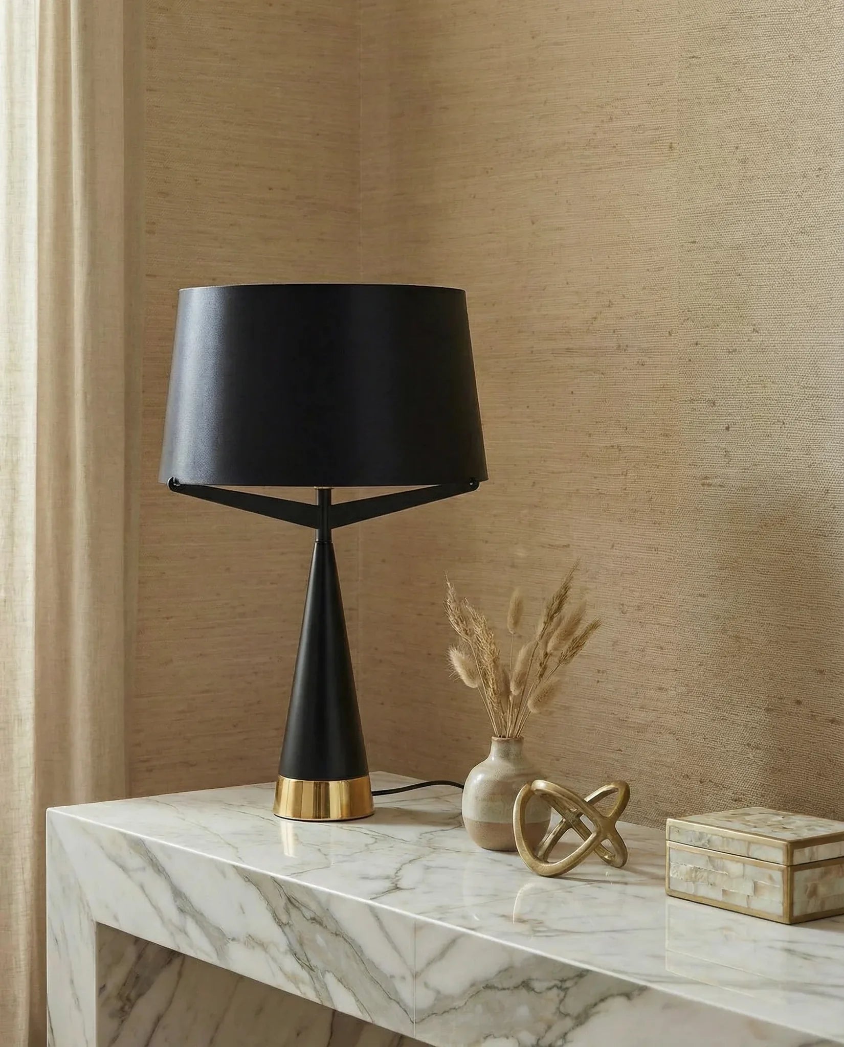 Jet black metal table lamp with gold accent on a bedside table