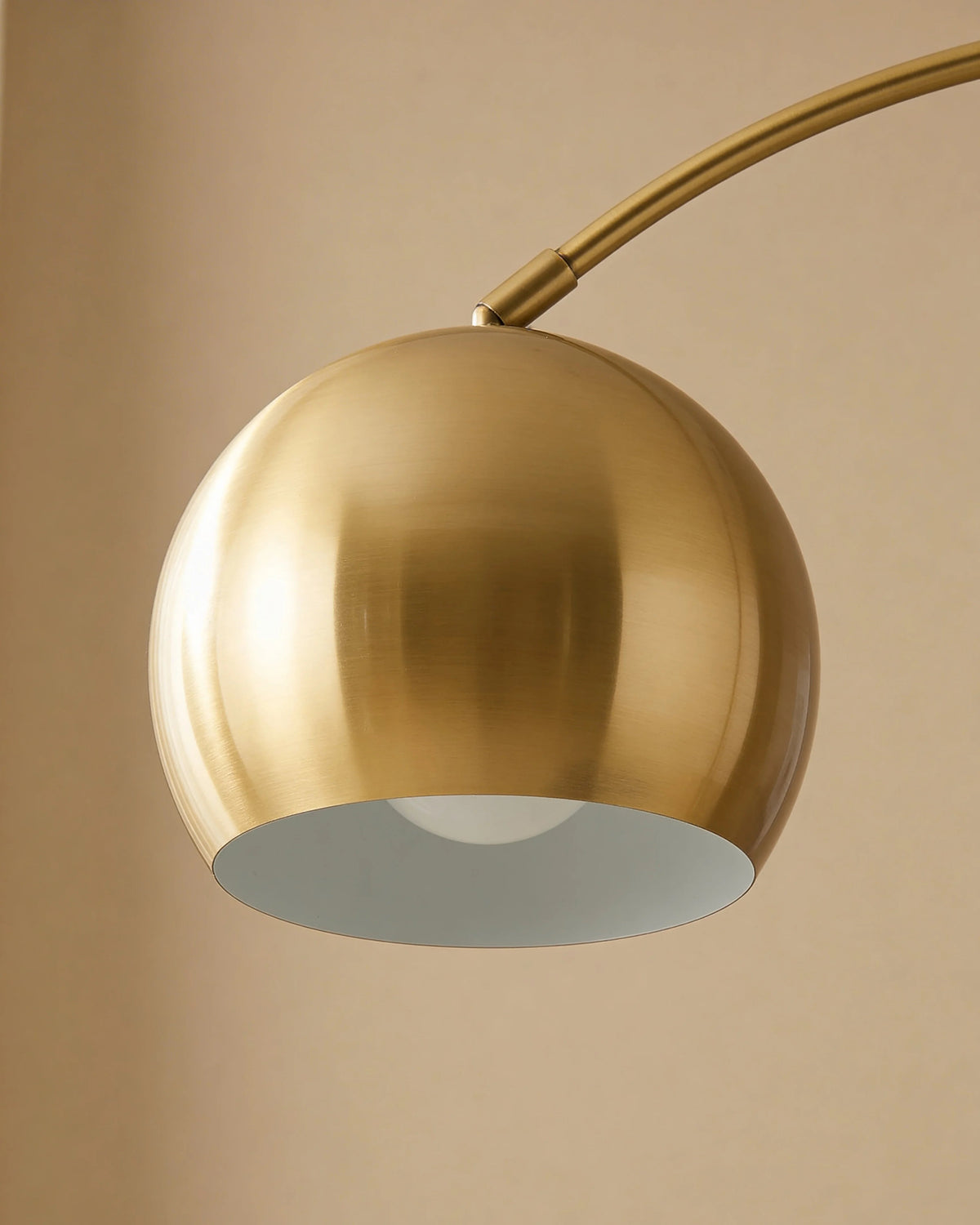 Gold arc floor lamp with side table in a Dubai living room