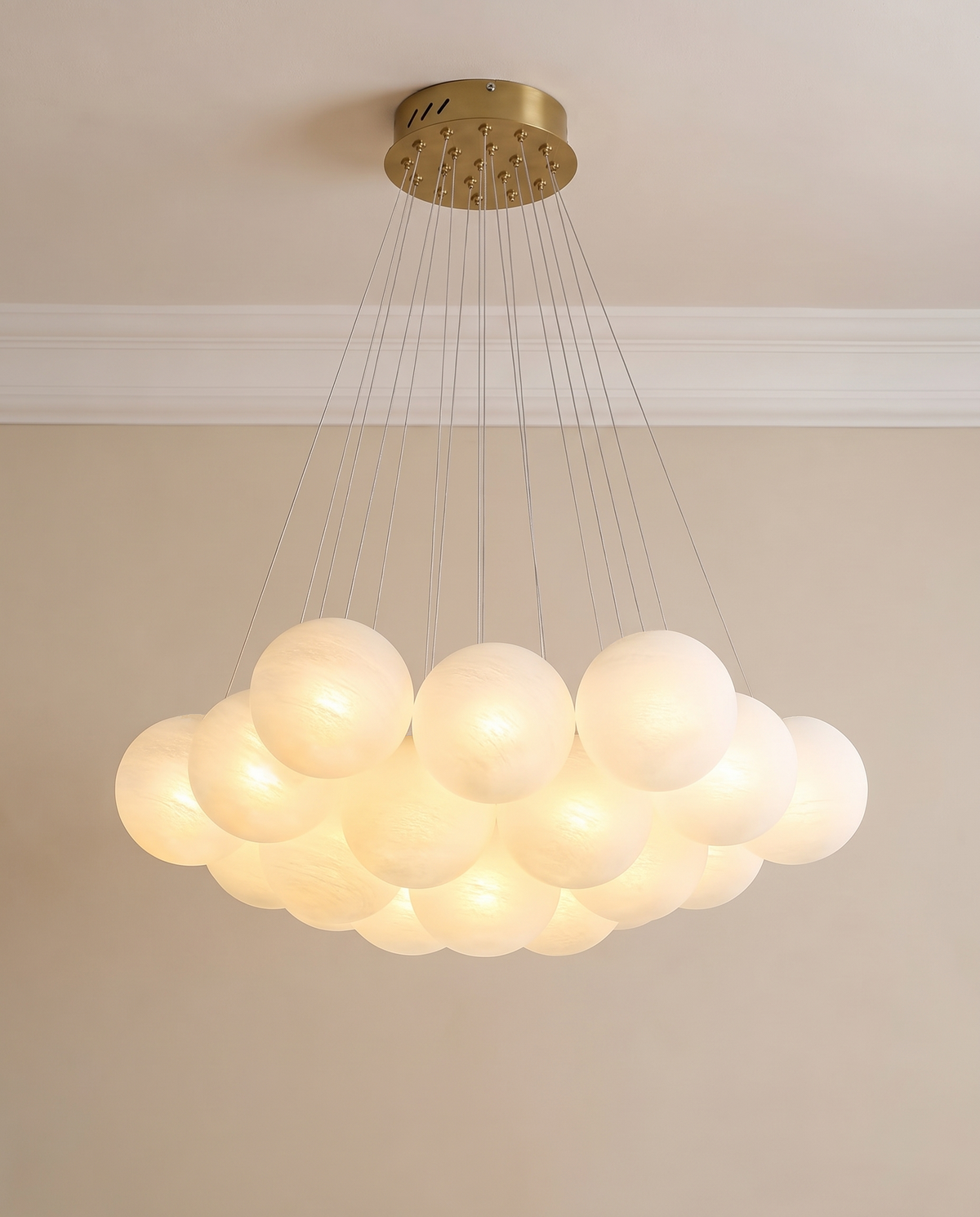 A modern multi-light cluster chandelier with frosted white spherical acrylic shades and a brushed gold ceiling canopy