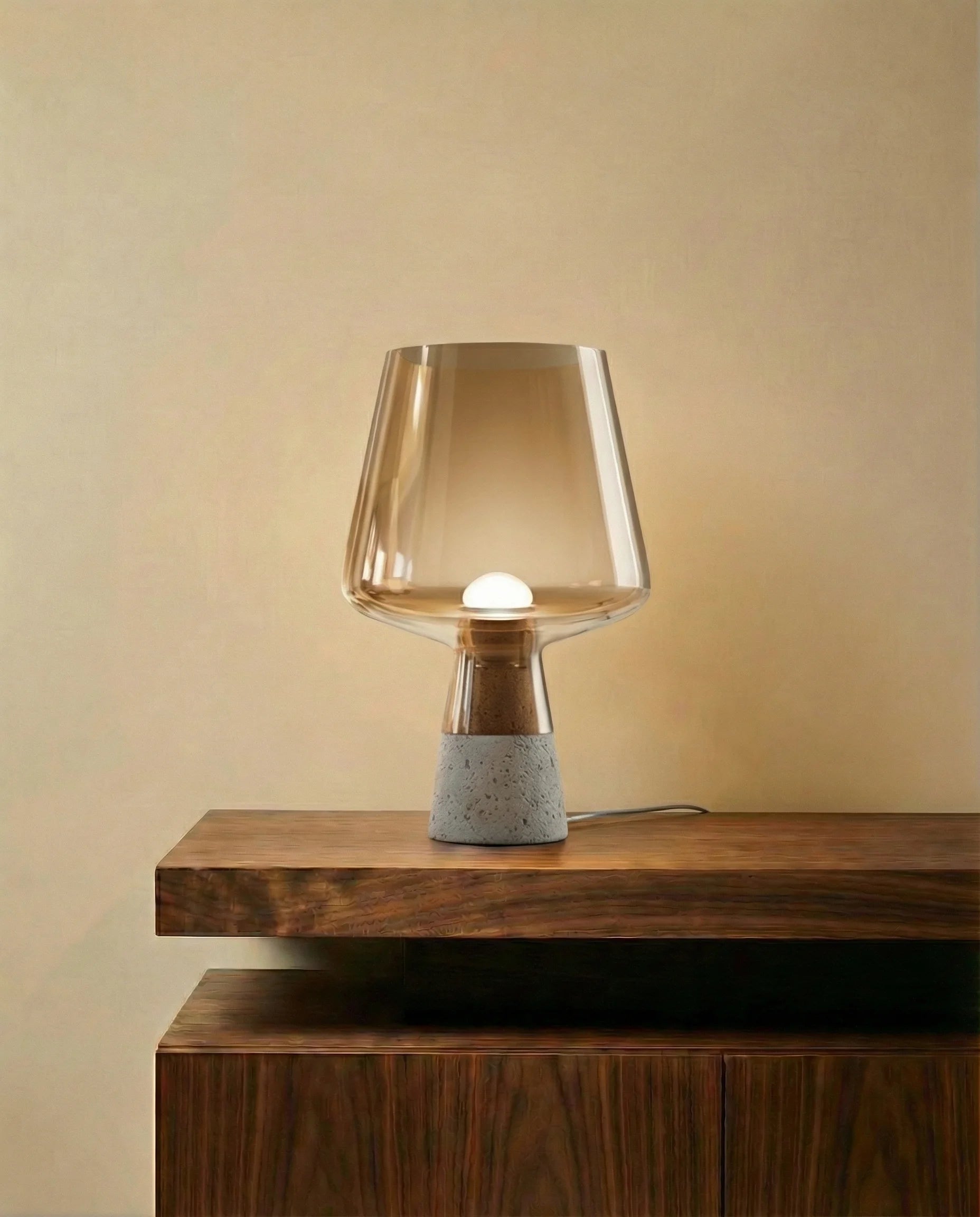Amber smokey glass table lamp on a concrete base