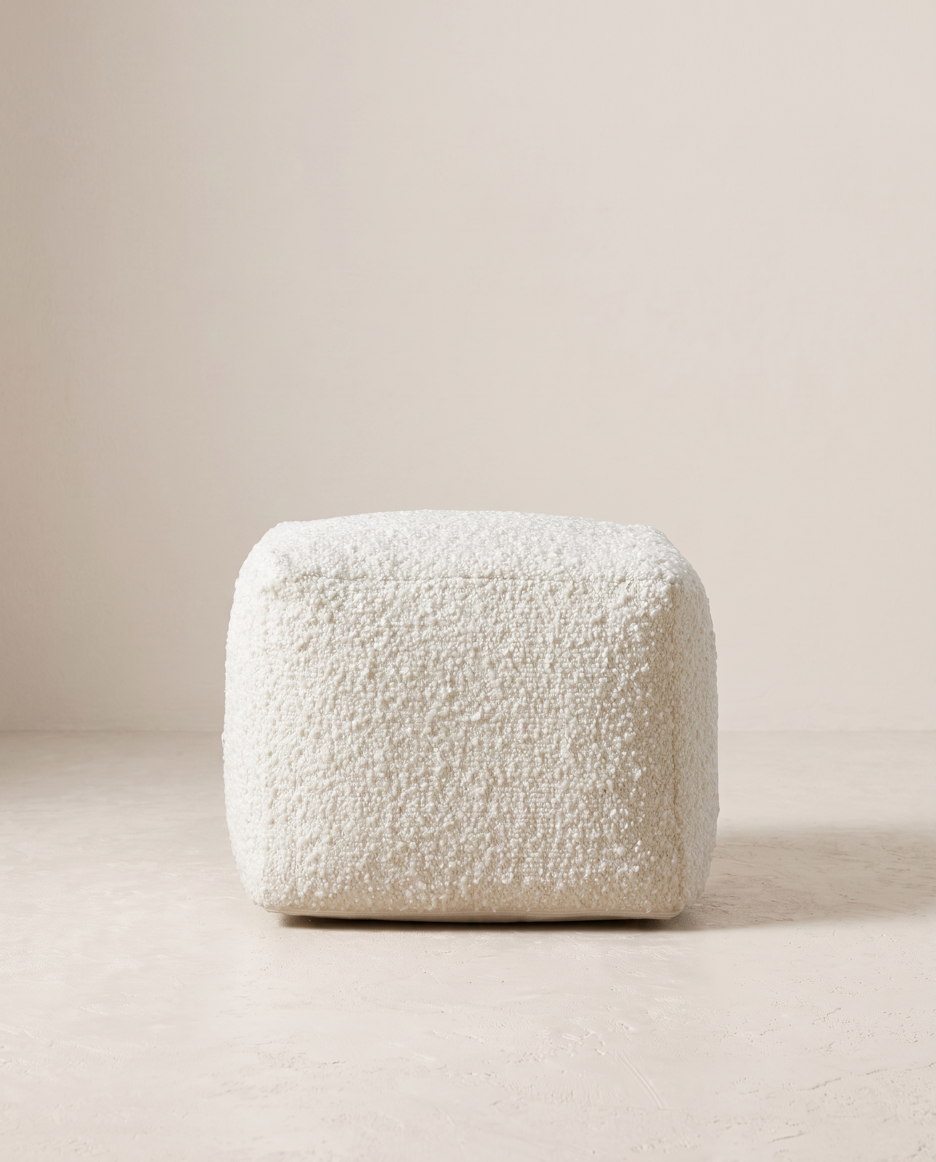 Juno ivory bouclé round pouf on plain backdrop