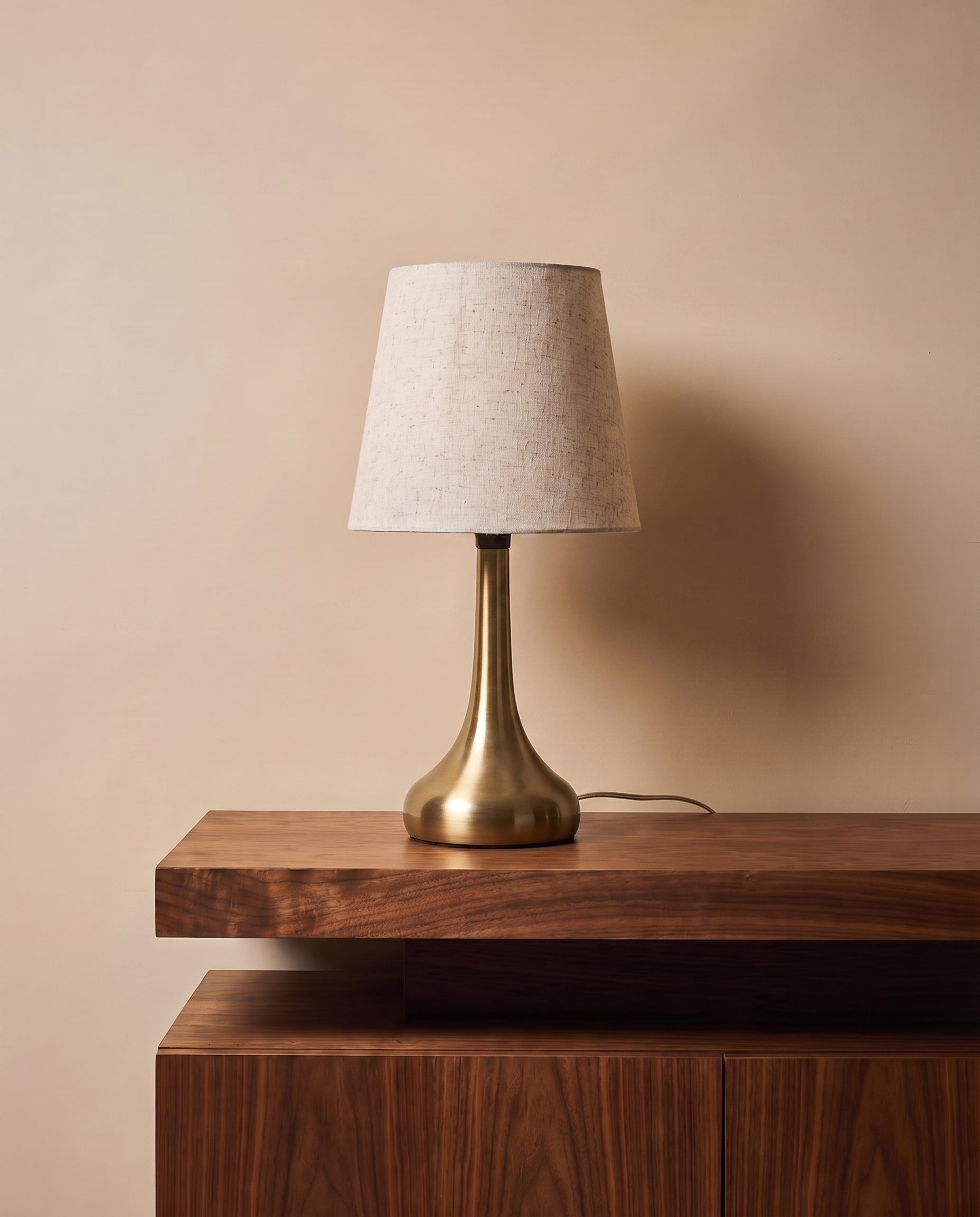 Compact gold table lamp with off-white shade