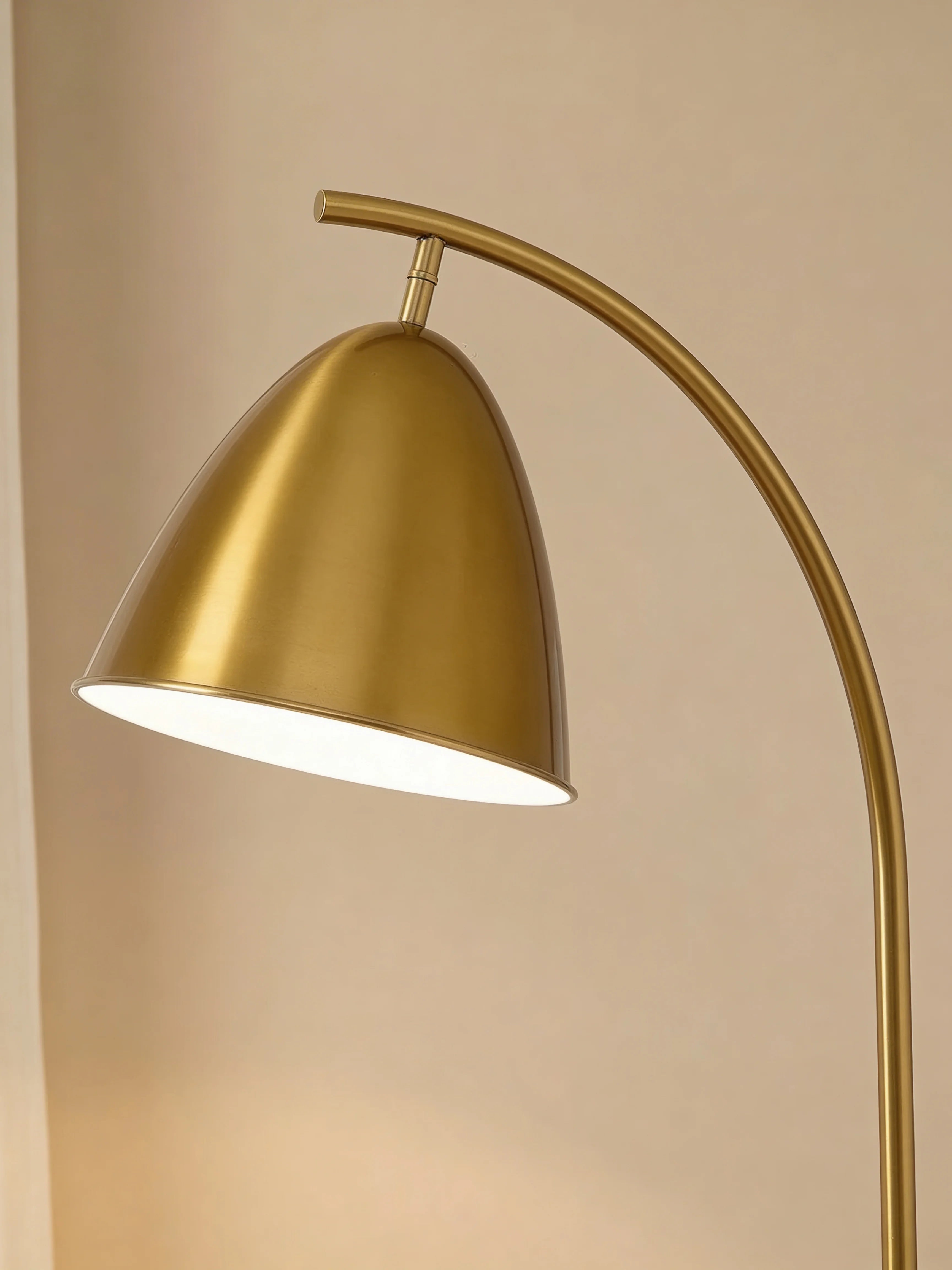 Gold arched floor lamp with table in a Dubai living room