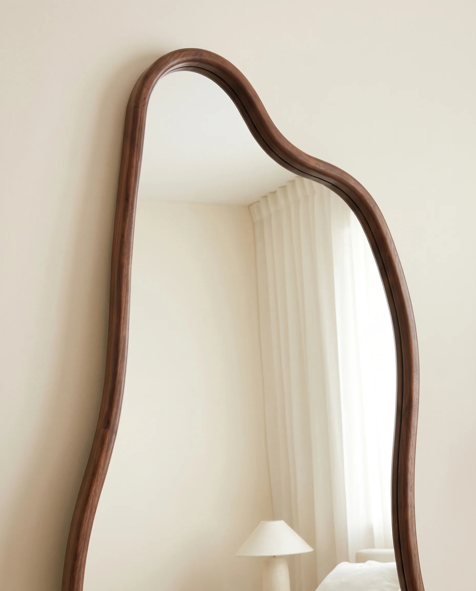 Hazel dark brown wavy mirror, close-up of the wood-tone frame
