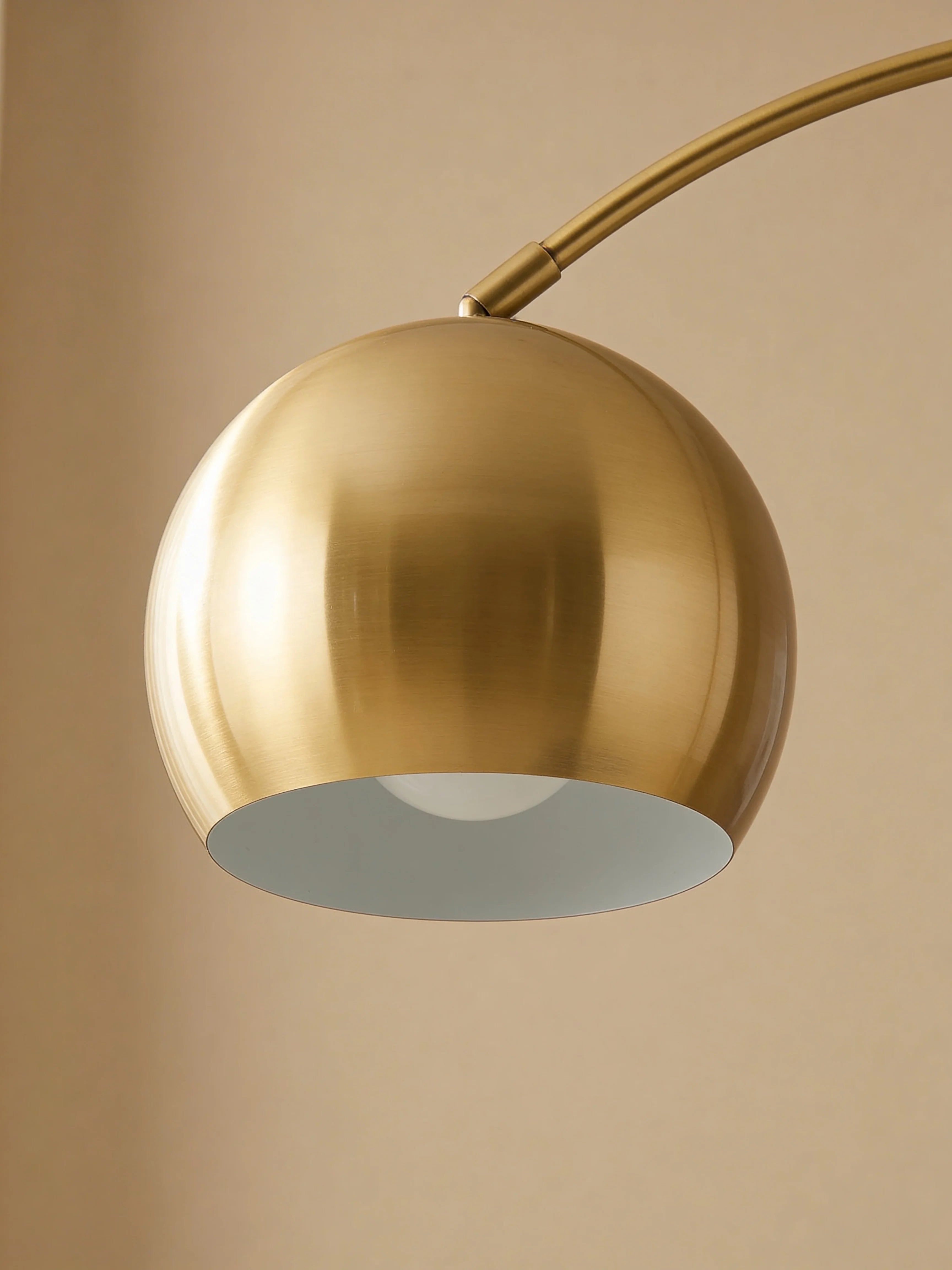 Gold arc floor lamp with side table in a Dubai living room
