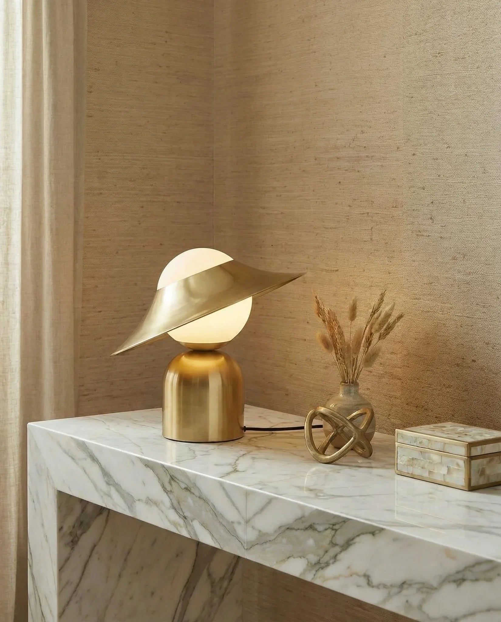 Tipped Hat gold glass table lamp on a console in a Dubai living room