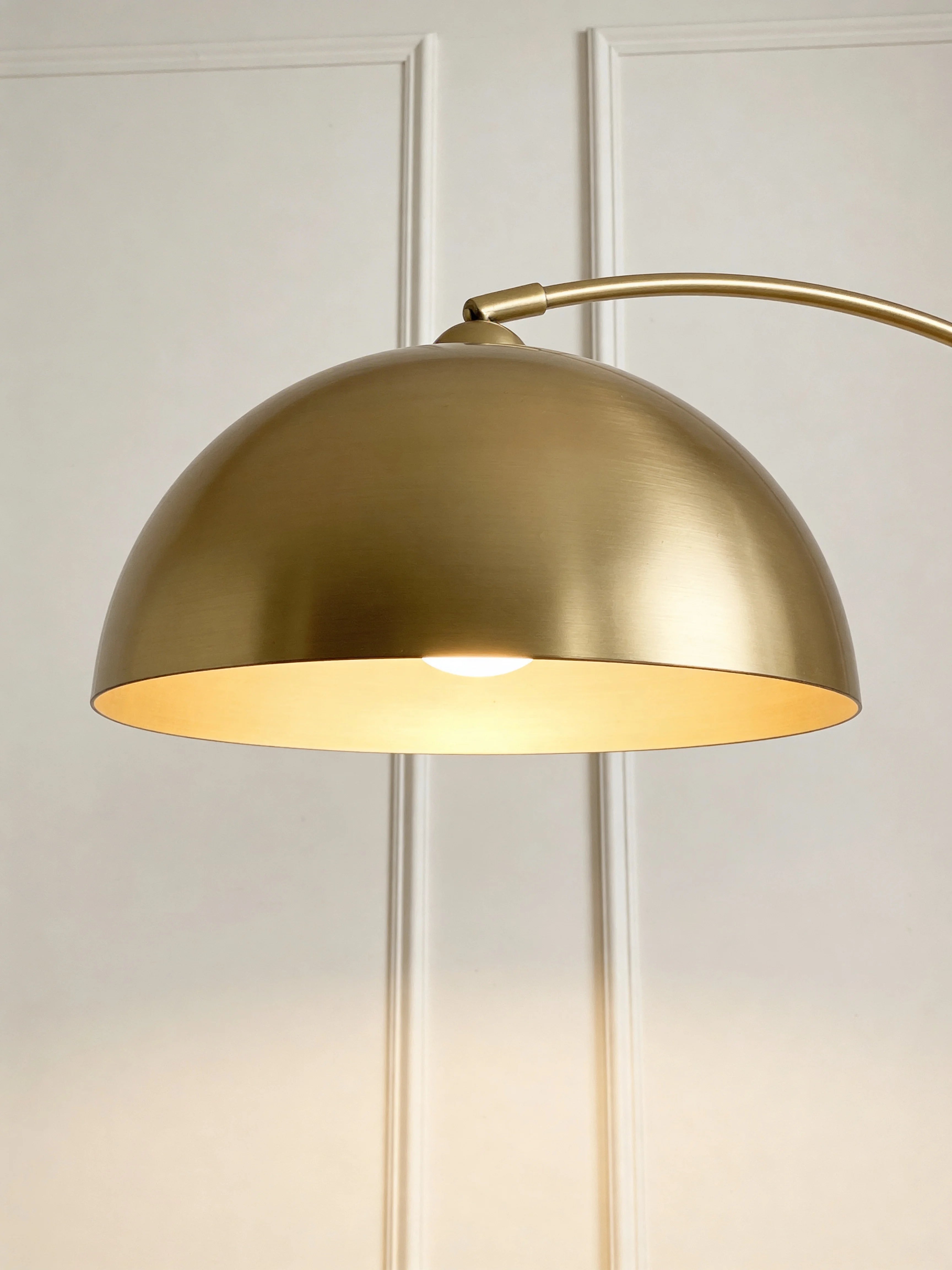 Gold arc floor lamp with table in a Dubai living room