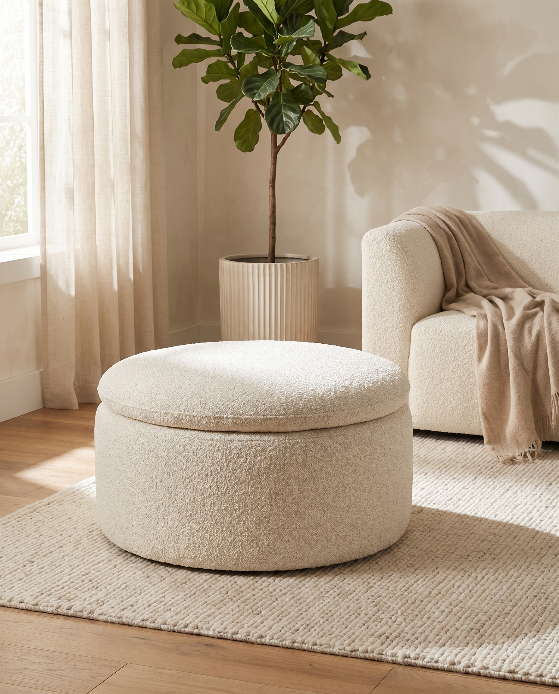 Romy cream bouclé storage pouf in a modern living room