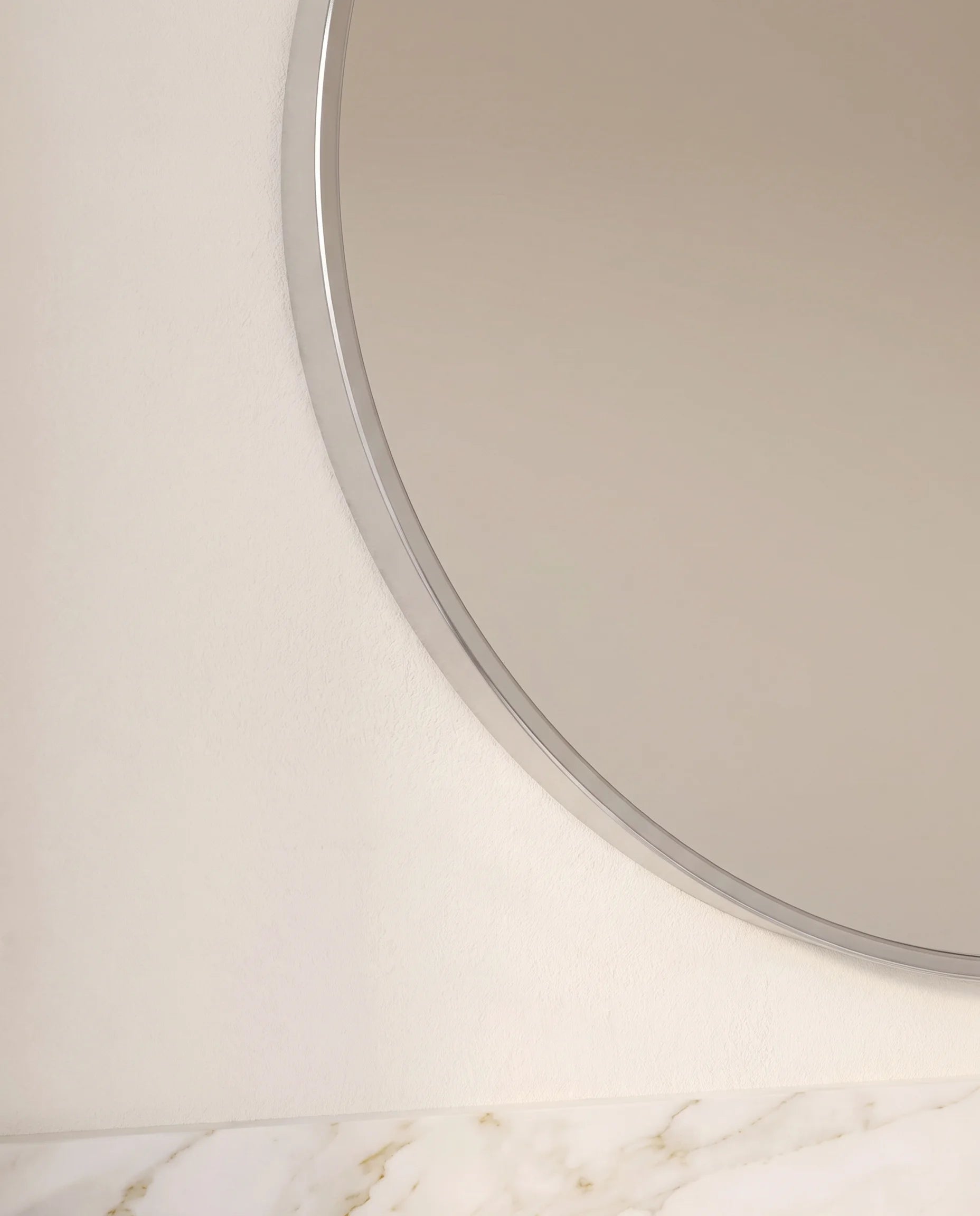 Modern silver round bathroom mirror, close-up of the slim frame