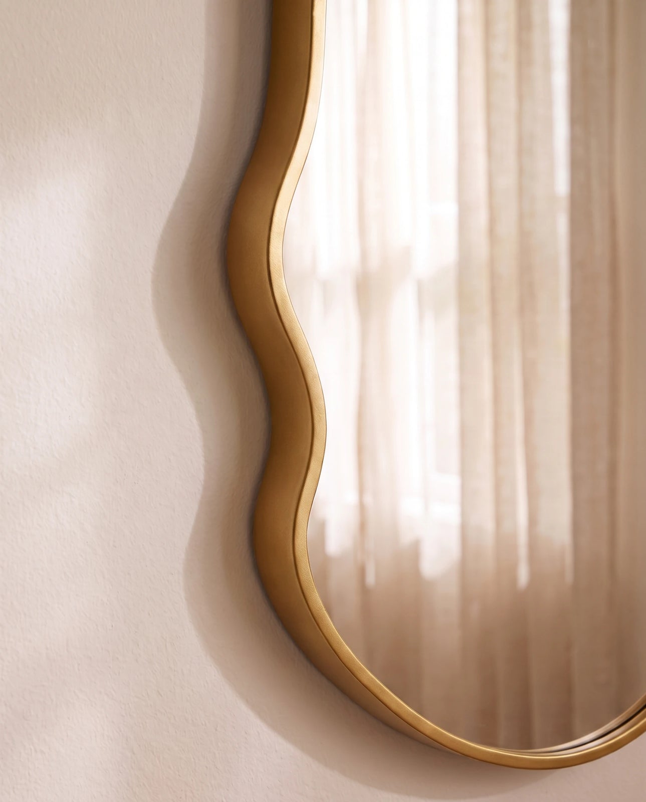 Onda gold irregular wall mirror in a Dubai living room
