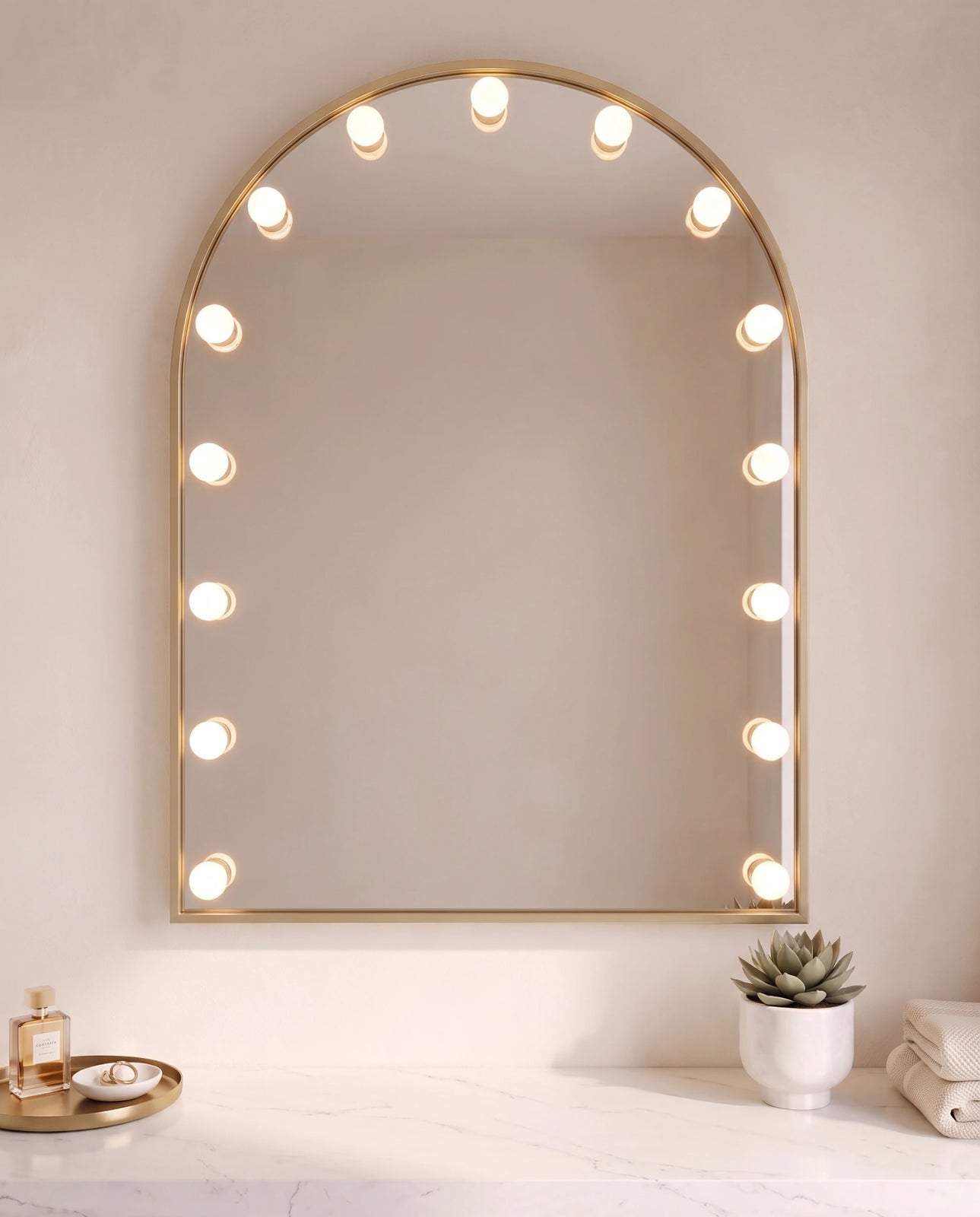 Soraya gold arch wall mirror with bulbs in a Dubai bathroom